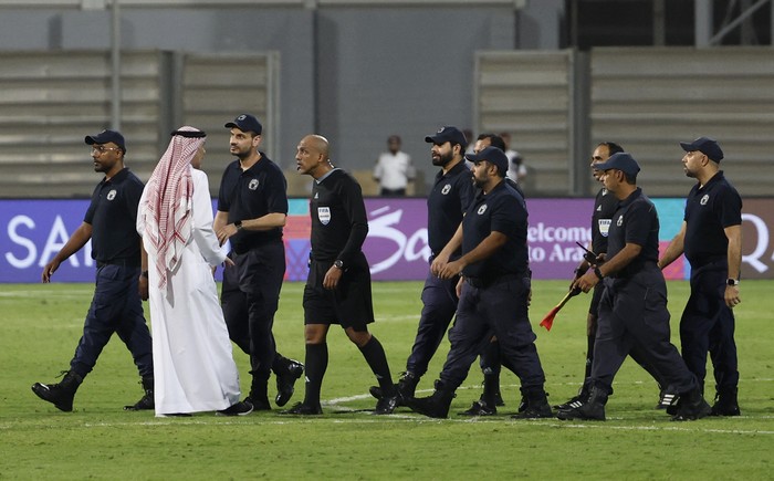 Foto Wasit Ahmed Al-Kaf Dikawal Polisi Usai Pimpin Laga Bahrain Vs Indonesia Soccer Football - World Cup - Asian Qualifiers - Third Round - Group C - Bahrain v Indonesia - Bahrain National Stadium, Riffa, Bahrain - October 10, 2024 Referee Ahmed Al-Kaf with police after the match REUTERS/Hamad I Mohammed